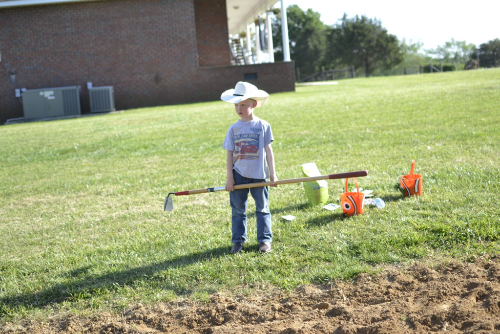 fun family traditions can be simple, child working in the garden
