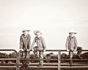my little cowboys on a fence
