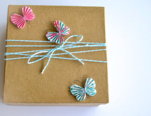 Gift box wrapped with decorative string and embellished with beautiful paper crafted butterflies.