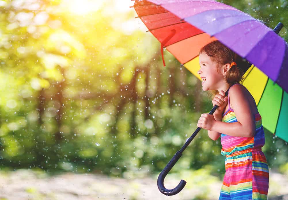 Little girl dancing in the rain for a fun summer activity!