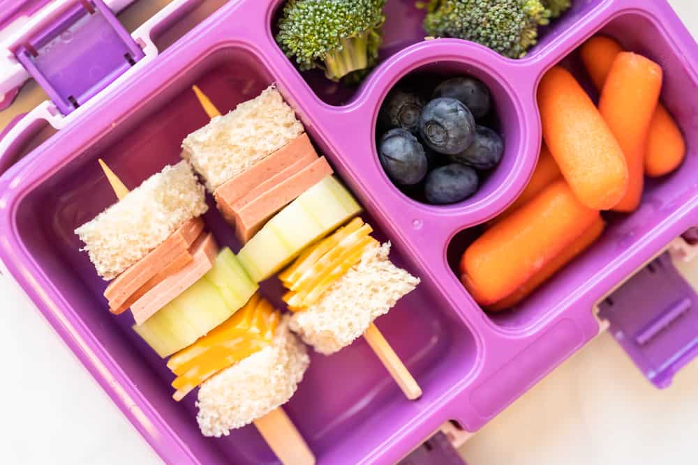 Flat lay. Healthy school lunch with kebab sandwich and vegetables in bento box.