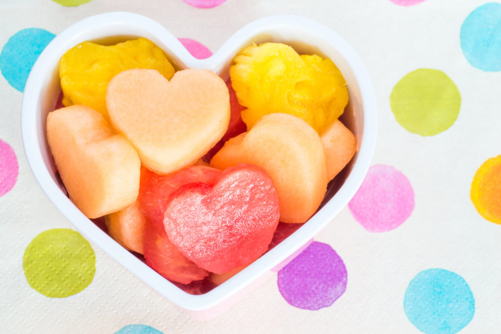 Valentines Day ideas of child friendly healthy treat with heart-shaped fruit cantaloupe, watermelon and pineapple