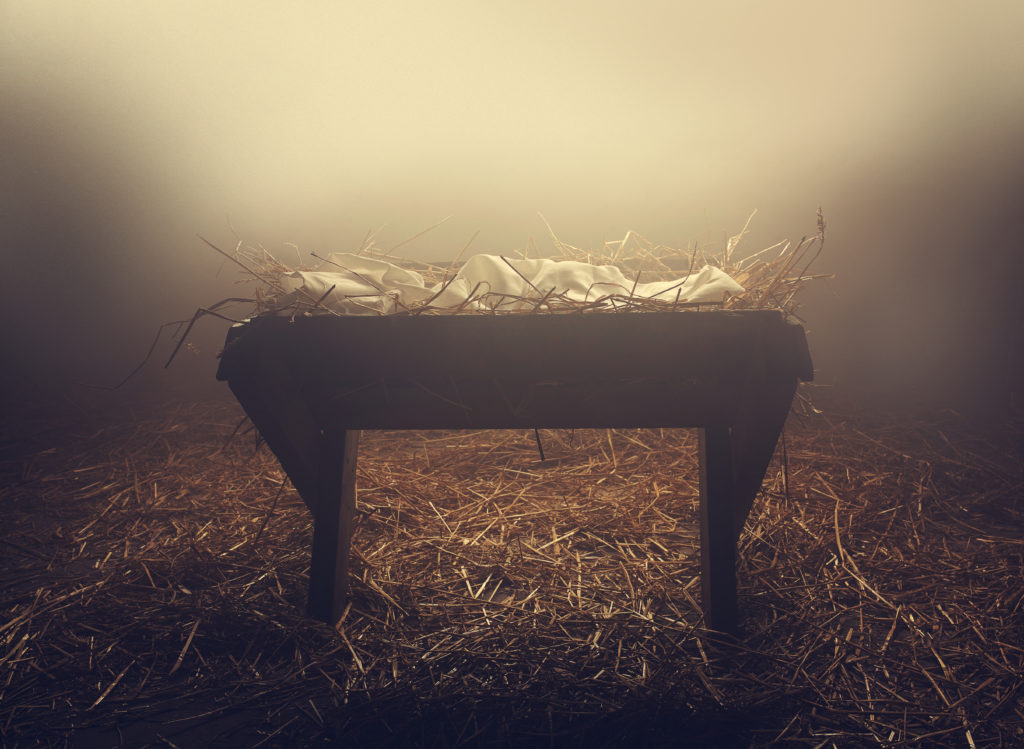 An empty manger at night under the fog.
